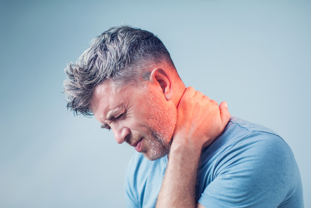 man suffering from neck pain